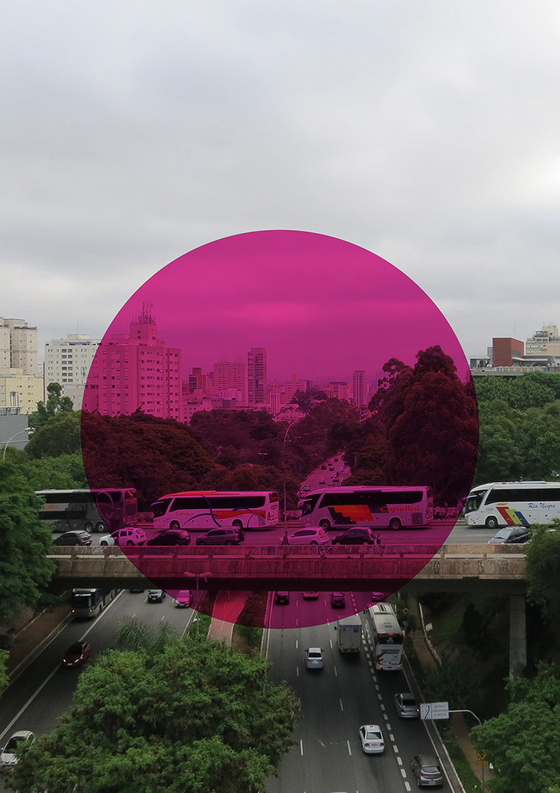Foto do viaduto na Av Sumaré em São Paulo. No centro da imagem os ônibus fretados sobre o viaduto são destacados com um grande círculo rosa. A imagem oferece uma visão ampla da avenida, na qual podem ser observadas as vias, as árvores nos canteiros laterais e os prédios altos ao fundo.